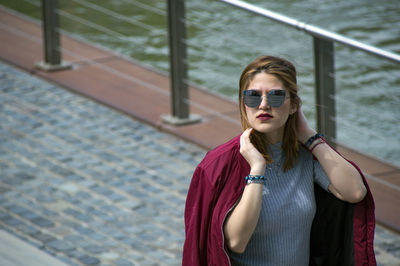 Portrait of young woman wearing sunglasses standing outdoors