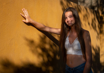 Portrait of woman standing against wall