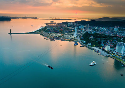 Aerial view of city by bay during sunset
