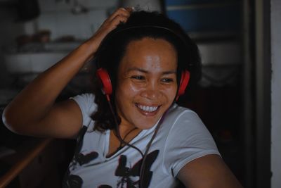 Smiling woman looking away while wearing headphones