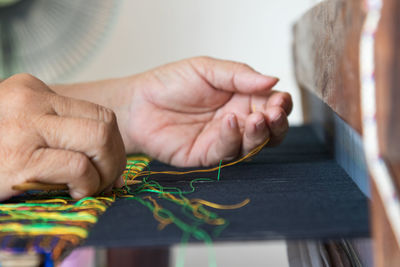 Cropped hand of woman weaving