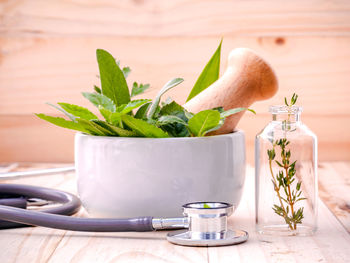 Close-up of herbs in mortar and pestle on table