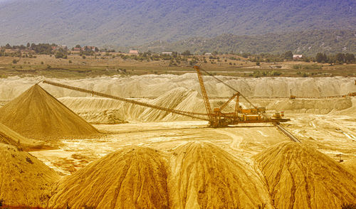 Own coal open pit landscape with enormous digging excavator selectiv focus
