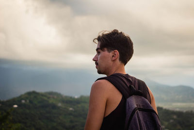 Man looking away against sky