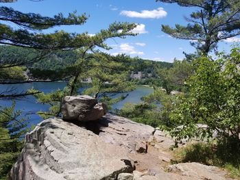 Rocks by lake against sky