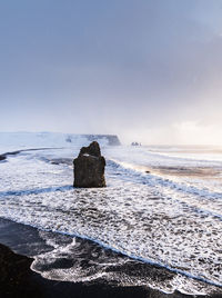 Scenic view of rock formation in sea against sky