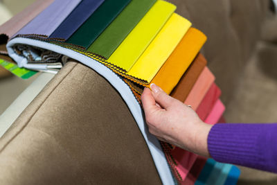 A women looks at tissue samples. selects the color of the sofa.