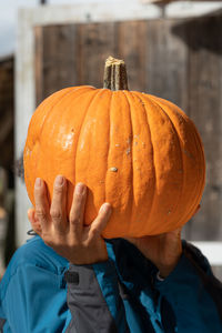 Midsection of man with pumpkin
