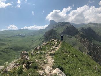 Rear view of man on mountain against sky