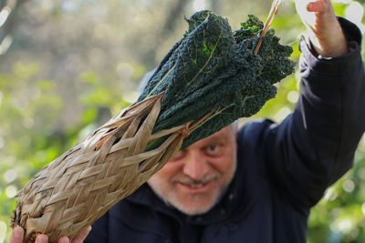 Portrait of man holding leaf outdoors