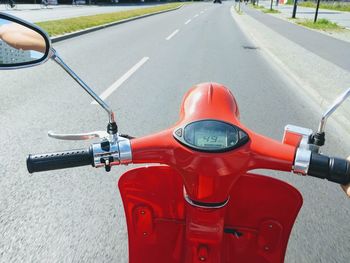 Close-up of red scooter on road