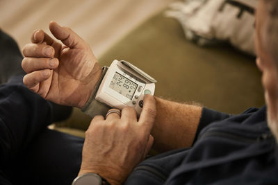 Senior man checking blood pressure at home