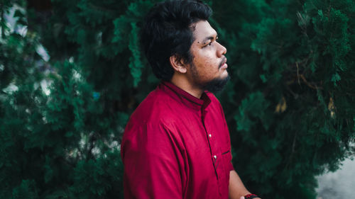 Young man looking away in forest