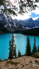 Scenic view of lake by snowcapped mountains against sky