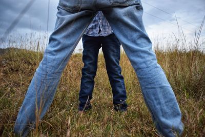 Low section of man standing on field