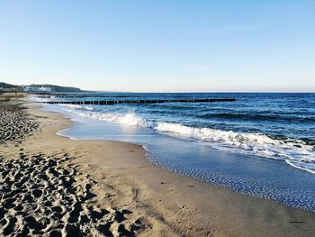 Scenic view of beach against clear blue sky