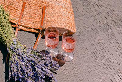 Two glasses with rose wine, bouquet of lavender flowers and straw bag. summer picnic