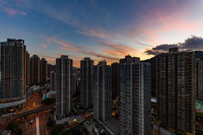 Aerial view of modern buildings in city against sky during sunset