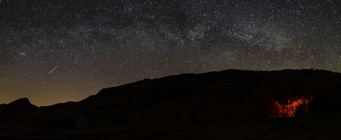 Scenic view of silhouette mountain against sky at night