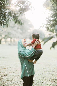 Rear view of mother and daughter on tree