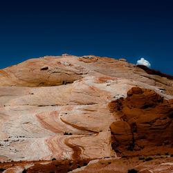 Low angle view of rock formations against clear blue sky