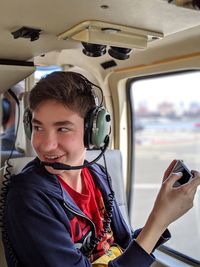 Smiling boy using mobile phone in helicopter