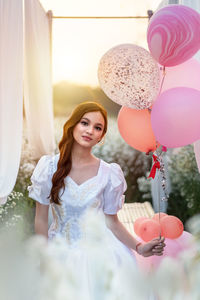 Portrait of a smiling young woman with balloons