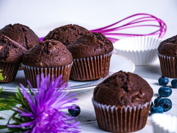 Close-up of flower and muffins on table