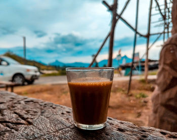 Close-up of coffee on glass against sky