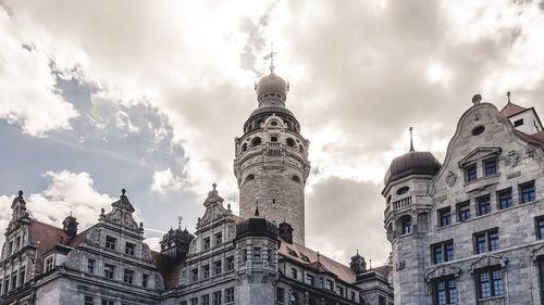 Low angle view of buildings against cloudy sky