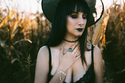 Woman wearing witch hat while standing at farm