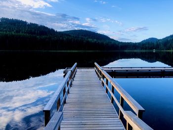 Wooden pier on lake against sky