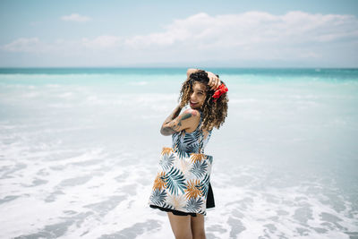 Woman with curly hair standing at beach