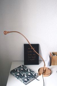 Diary and table lamp against wall