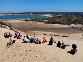 People on beach against clear sky