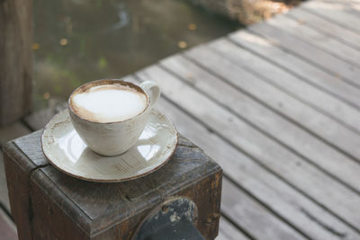 High angle view of coffee on wood fence post