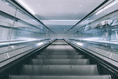 Low angle view of escalator in illuminated building