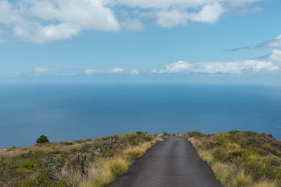 Road by sea against sky