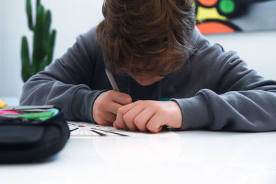 Close-up of boy drawing on table