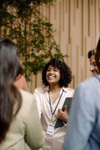Smiling businesswoman interacting with delegates in seminar at convention center