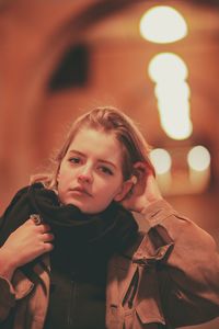 Portrait of young woman holding illuminated lighting equipment