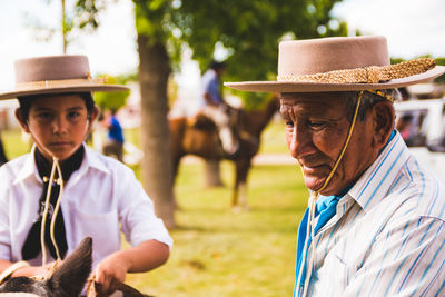 Close-up of grandfather and grandson wearing cowboy hat