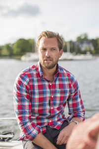 Mid adult man sitting on yacht at river