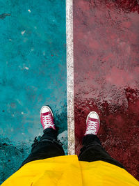 Low section of person standing against yellow wall