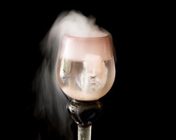 Close-up of wineglass against black background