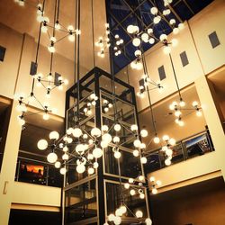 Low angle view of illuminated chandelier hanging on ceiling at restaurant