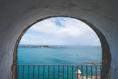 Scenic view of sea against sky seen through railing