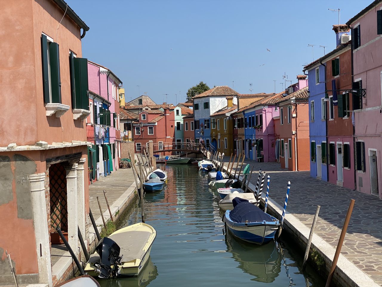 BOATS MOORED ON CANAL BY BUILDINGS AGAINST SKY