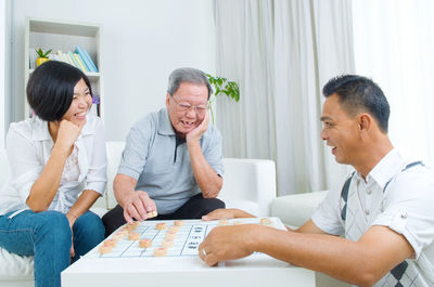 Happy family playing board game at home