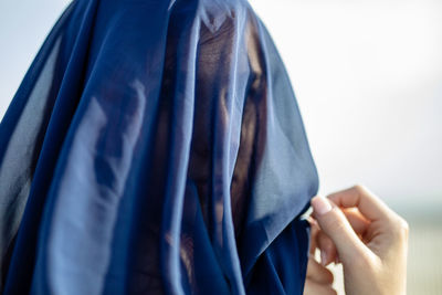 Close-up of woman covered with navy blue textile